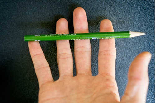 placing a pencil on the middle finger